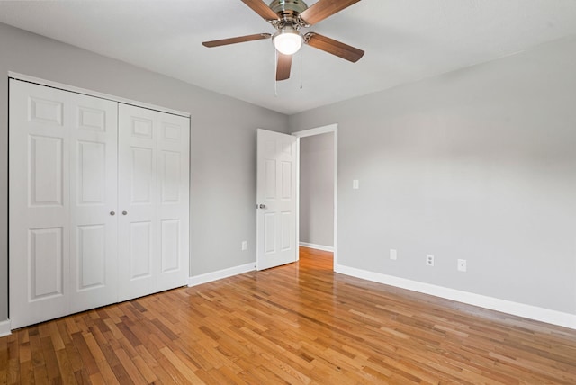 unfurnished bedroom featuring light wood-style floors, baseboards, a closet, and ceiling fan