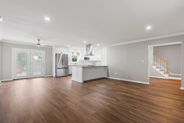 kitchen with freestanding refrigerator, exhaust hood, open floor plan, crown molding, and baseboards