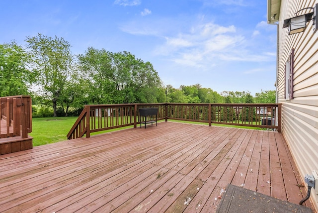 deck featuring a yard and view of wooded area