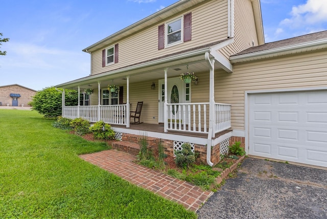 country-style home featuring a porch, a front lawn, and asphalt driveway