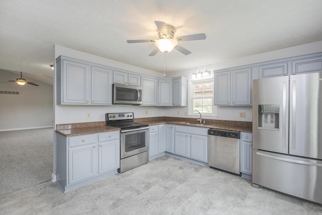 256 Sutton Ln, Lancaster, KY 40444 - kitchen with stainless steel appliances, ceiling fan, a sink, dark countertops, and gray cabinetry