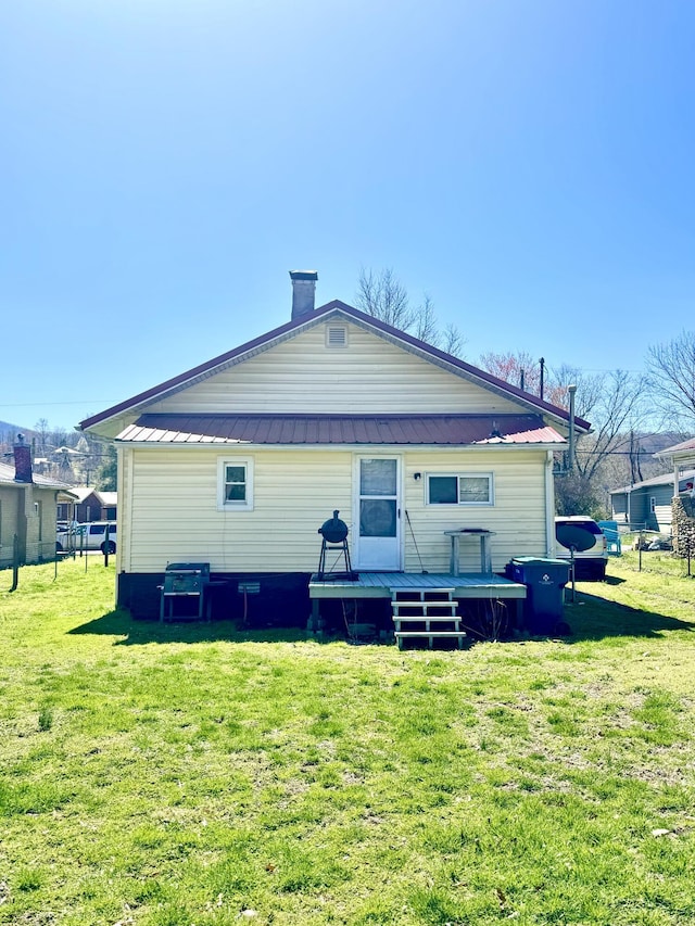 112 Exeter Ave, Middlesboro, KY 40965 - rear view of house featuring a chimney, metal roof, a deck, and a lawn