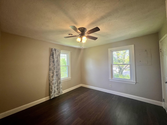 unfurnished room with ceiling fan, a textured ceiling, baseboards, and dark wood-style flooring
