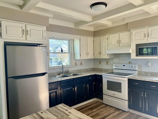 kitchen featuring beamed ceiling, a sink, blue cabinetry, and appliances with stainless steel finishes