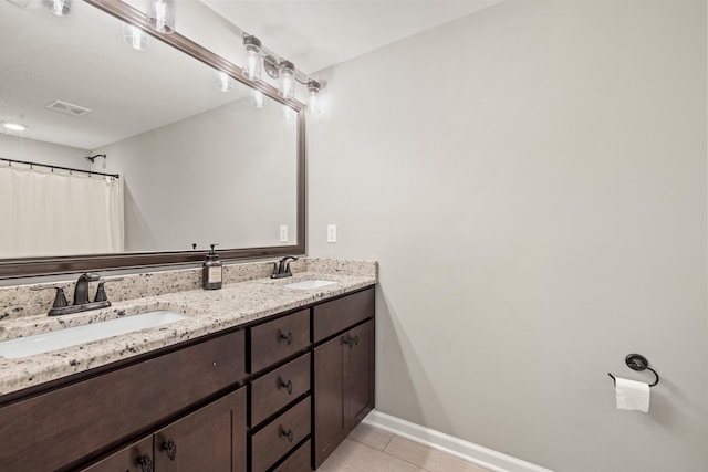 bathroom featuring double vanity, visible vents, baseboards, and a sink