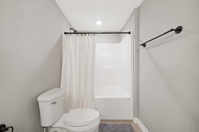 bathroom featuring shower / tub combo, toilet, and wood finished floors