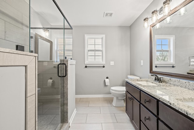 bathroom with baseboards, toilet, a shower stall, visible vents, and a sink