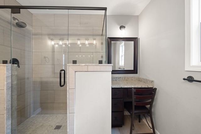 bathroom featuring a shower stall and vanity