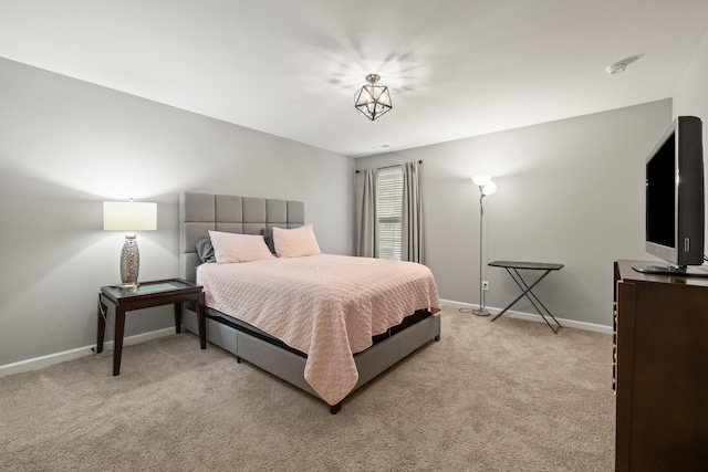 bedroom with baseboards and light colored carpet