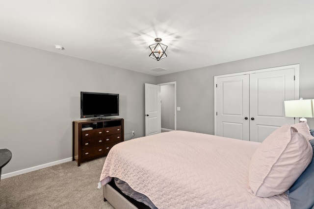 carpeted bedroom featuring visible vents, a closet, and baseboards