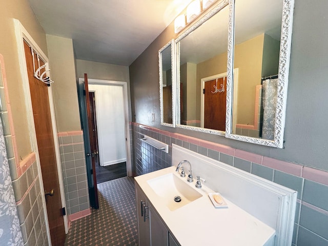 bathroom with wainscoting, vanity, and tile walls
