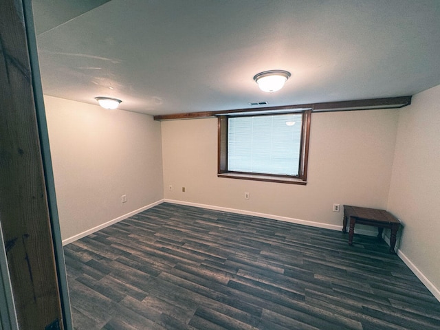 empty room featuring baseboards, visible vents, and wood finished floors