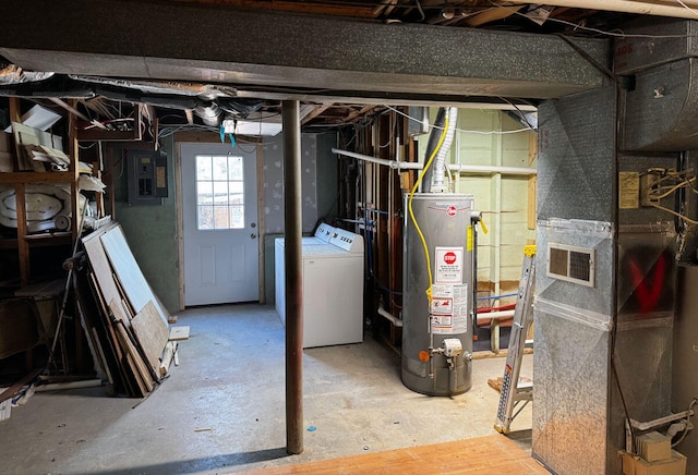 basement featuring heating unit, gas water heater, electric panel, and washer and dryer