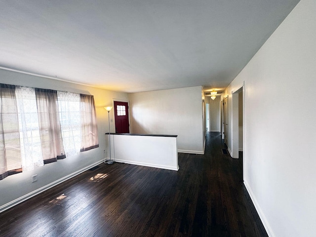 unfurnished room featuring baseboards and wood finished floors