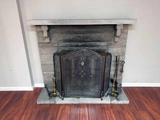 room details with baseboards, a fireplace, and wood finished floors