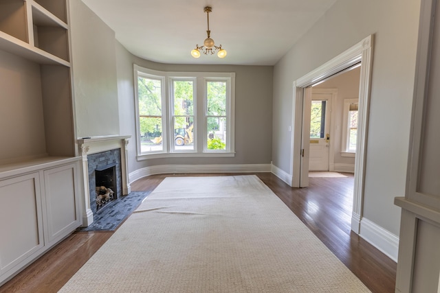 261 N Broadway, Lexington, KY 40507 - unfurnished living room with healthy amount of natural light, a stone fireplace, dark wood finished floors, and baseboards