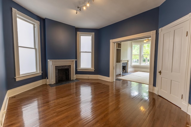 261 N Broadway, Lexington, KY 40507 - unfurnished living room featuring a fireplace with flush hearth, wood finished floors, baseboards, and rail lighting