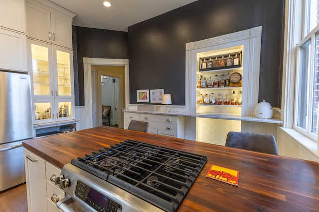 261 N Broadway, Lexington, KY 40507 - kitchen with butcher block counters, freestanding refrigerator, white cabinetry, glass insert cabinets, and wood finished floors