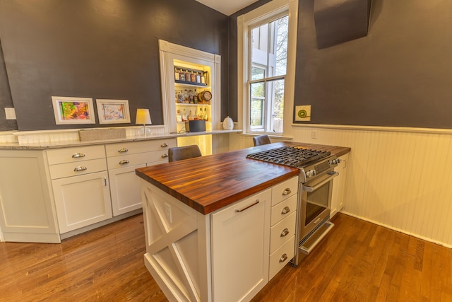 261 N Broadway, Lexington, KY 40507 - kitchen featuring wood counters, high end stove, wainscoting, dark wood-style floors, and white cabinets