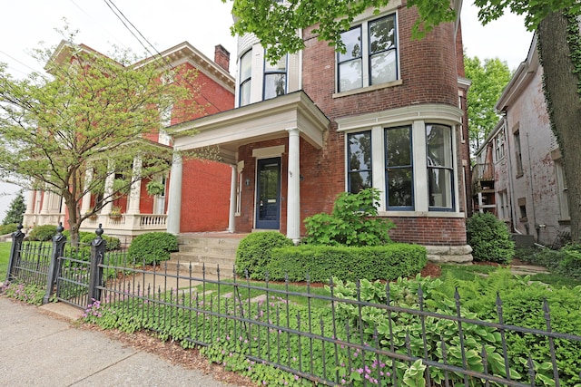 261 N Broadway, Lexington, KY 40507 - view of front facade featuring brick siding, a porch, and a fenced front yard