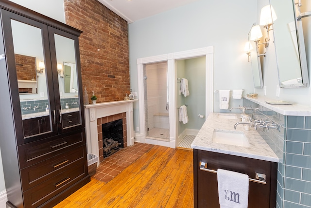 261 N Broadway, Lexington, KY 40507 - full bath featuring wood finished floors, vanity, a stall shower, and a tiled fireplace