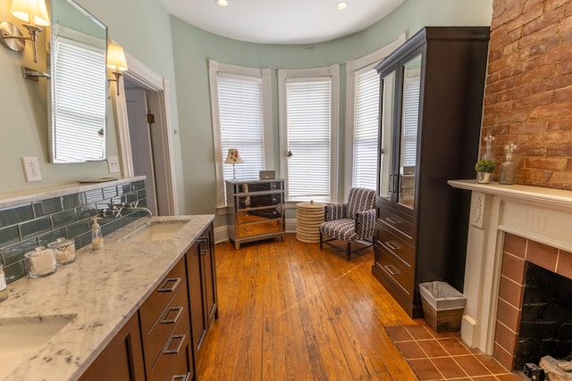 261 N Broadway, Lexington, KY 40507 - bathroom featuring a tiled fireplace, healthy amount of natural light, wood-type flooring, double vanity, and recessed lighting