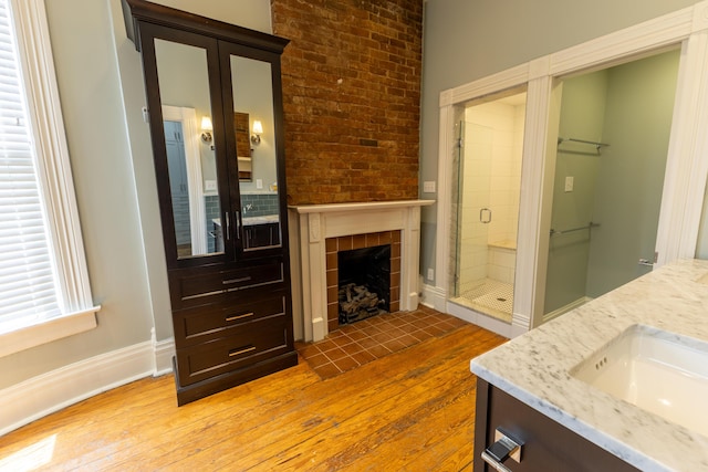 261 N Broadway, Lexington, KY 40507 - full bath with hardwood / wood-style floors, vanity, a stall shower, a tile fireplace, and baseboards