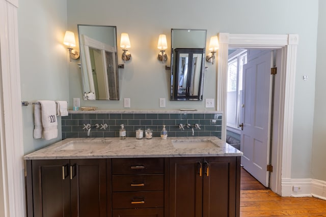 261 N Broadway, Lexington, KY 40507 - bathroom with double vanity, wood finished floors, and decorative backsplash
