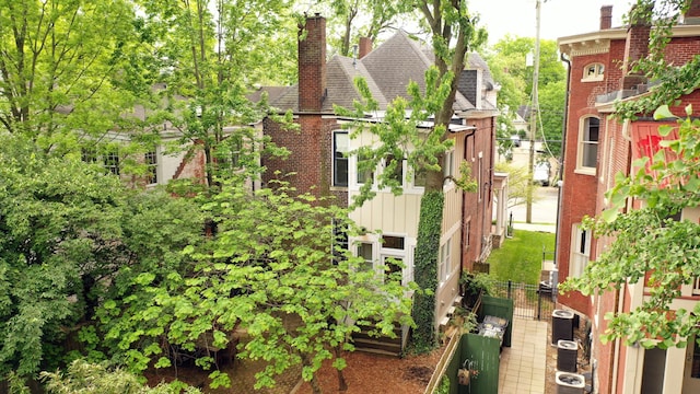 261 N Broadway, Lexington, KY 40507 - exterior space with roof with shingles, central AC unit, brick siding, and a chimney