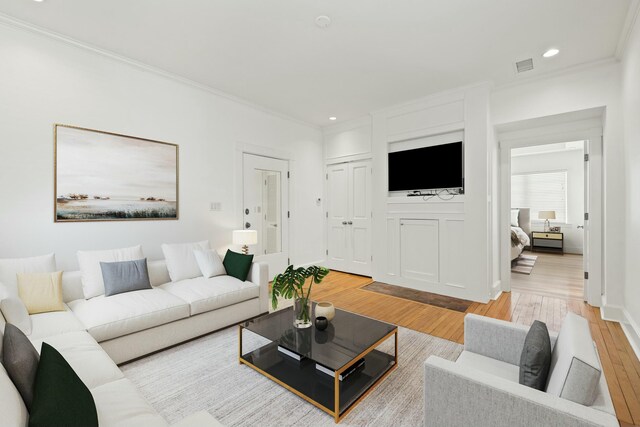 living area with ornamental molding, visible vents, recessed lighting, and light wood-type flooring
