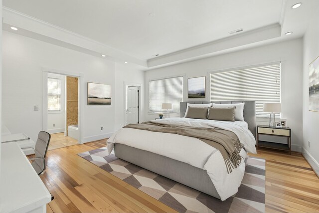 bedroom with recessed lighting, baseboards, a raised ceiling, light wood finished floors, and visible vents