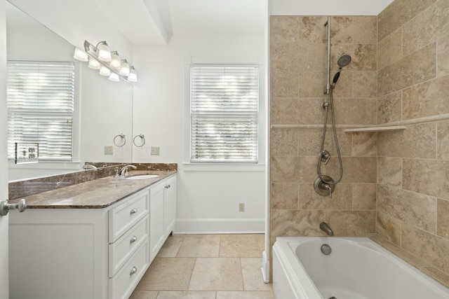 full bath featuring vanity, baseboards, and washtub / shower combination