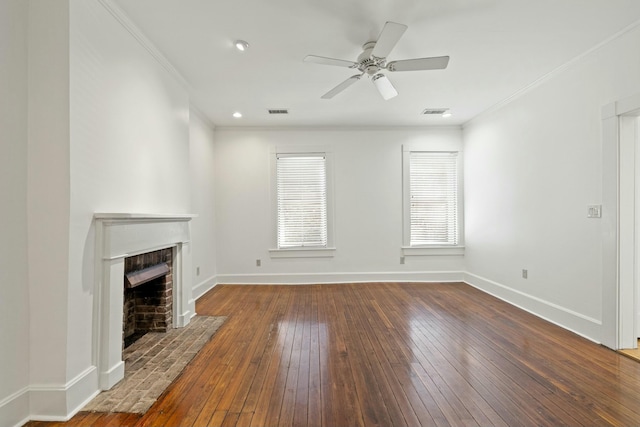 unfurnished living room featuring hardwood / wood-style floors, ornamental molding, baseboards, visible vents, and a brick fireplace