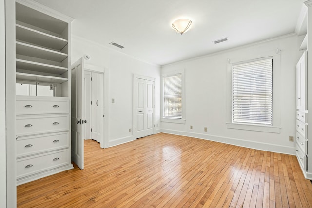 unfurnished bedroom featuring baseboards, visible vents, light wood-style flooring, and ornamental molding