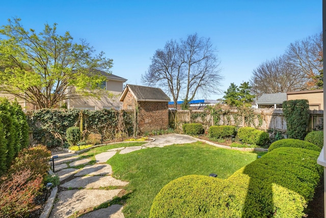 view of yard featuring an outbuilding, a storage unit, and a fenced backyard