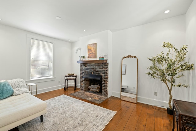 living room featuring hardwood / wood-style floors, a fireplace, baseboards, and recessed lighting