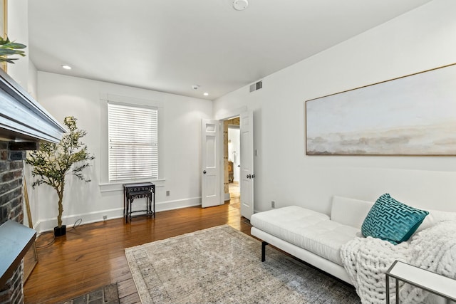 living area with recessed lighting, hardwood / wood-style floors, baseboards, visible vents, and a fireplace