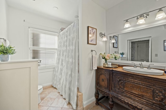 bathroom with baseboards, a shower with shower curtain, toilet, and vanity