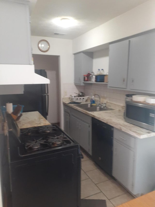 1281 Village Dr Unit C-9, Lexington, KY 40504 - kitchen with light tile patterned flooring, light countertops, a sink, backsplash, and black appliances