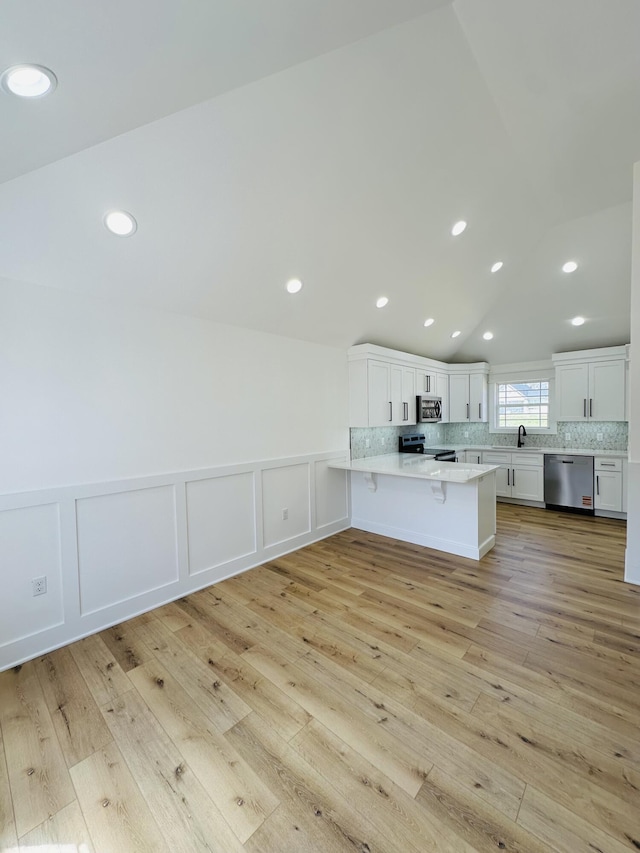 217 Dogwood Ln, Somerset, KY 42503 - kitchen featuring light countertops, light wood finished floors, a peninsula, stainless steel appliances, and decorative backsplash