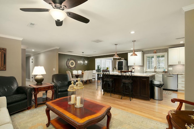 living area featuring recessed lighting, light wood-style flooring, crown molding, a ceiling fan, and visible vents
