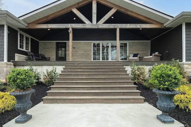 property entrance featuring covered porch and stone siding