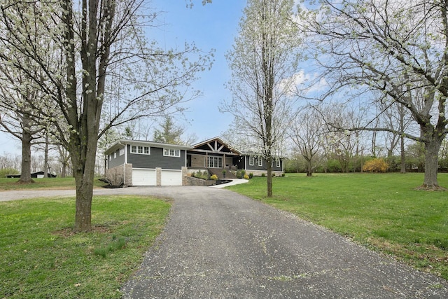 view of front of property featuring an attached garage, driveway, and a front lawn