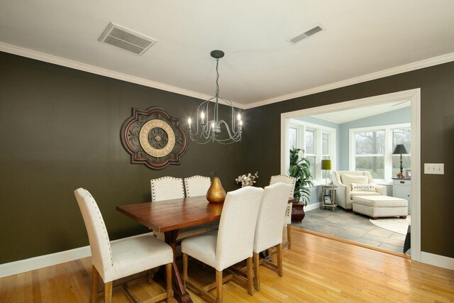 dining room featuring visible vents, a chandelier, and wood finished floors
