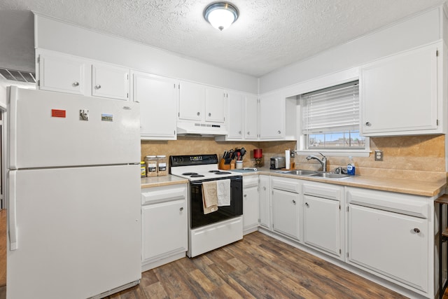 kitchen featuring freestanding refrigerator, dark wood-type flooring, under cabinet range hood, a sink, and range with electric cooktop