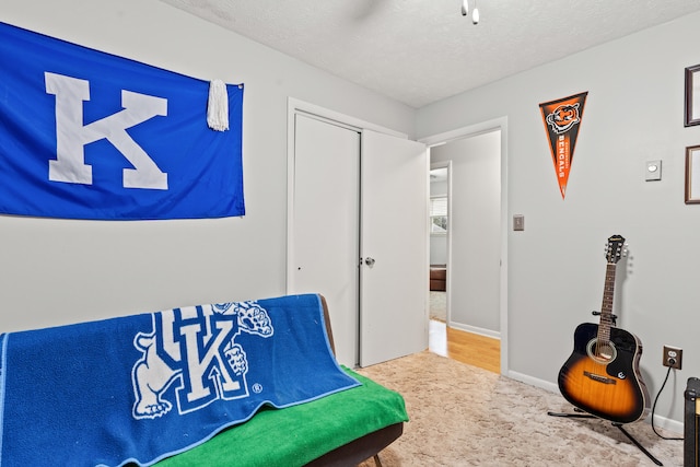 bedroom with a closet, baseboards, a ceiling fan, carpet, and a textured ceiling