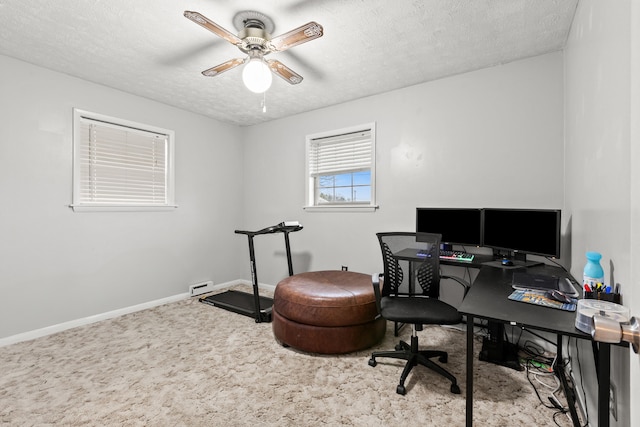 carpeted home office featuring ceiling fan, baseboards, and a textured ceiling