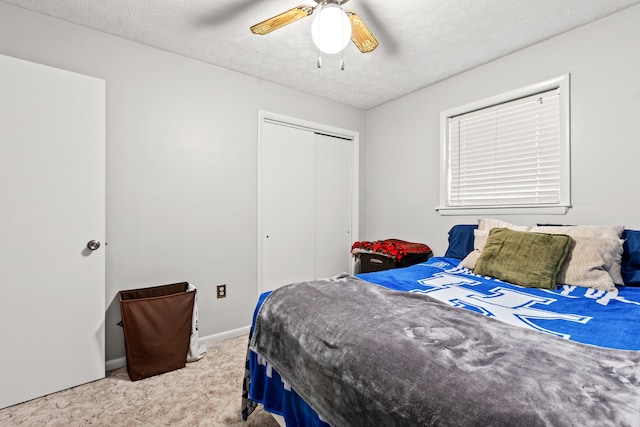 bedroom with baseboards, a closet, carpet flooring, a textured ceiling, and ceiling fan