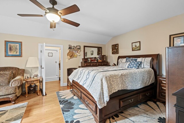 bedroom with a ceiling fan, light wood finished floors, vaulted ceiling, and baseboards