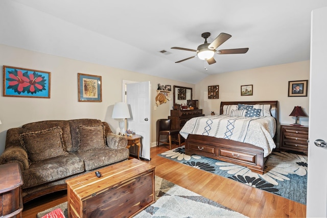 bedroom with lofted ceiling, visible vents, a ceiling fan, and wood finished floors